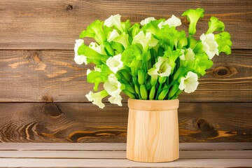 vase filled with fresh green and white flowers on a wooden table Generative AI