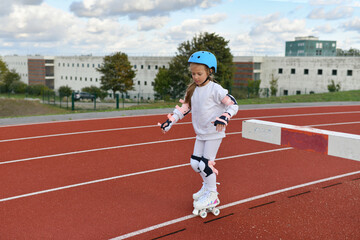 Fototapeta premium A girl in vintage white roller skates and a helmet at the stadium