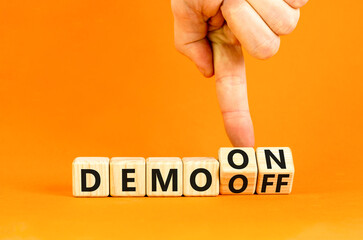 Demo on or off symbol. Businessman turns wooden cubes and changes word Demo off to Demo on....