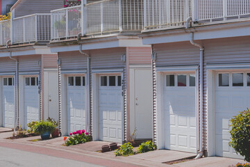 Garage doors with driveway. Nice neighborhood. Row of garage doors at parking area for townhouses. Concrete driveway