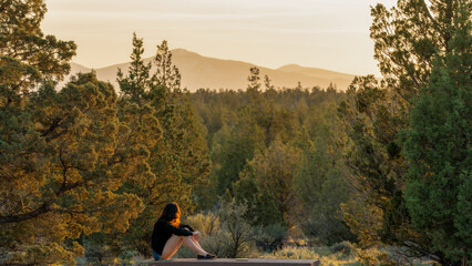 Woman Watches as the Sun Sets Over the Cascades in Bend Central Oregon