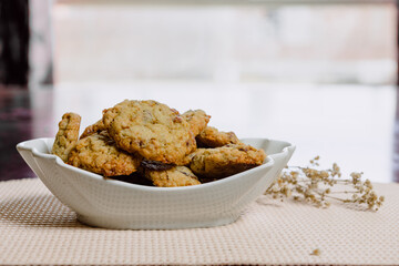 Pumpkin, oat cookies with cranberries, almond on a bowl in a kitchen.