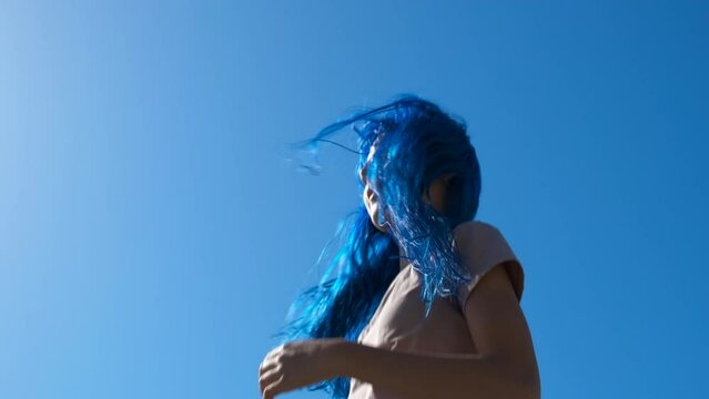 Blue sky with trampoline jumping teen. A view of active blue girl jumping on trampoline during sunny day.