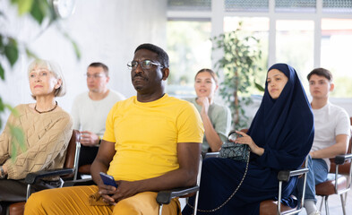 Portrait of focused African American man participating study session, sitting in auditorium with...