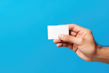 Close up male hand and levitating card isolated on blue background Generative AI