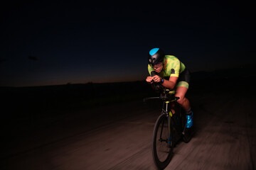 A triathlete rides his bike in the darkness of night, pushing himself to prepare for a marathon....