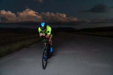 A triathlete rides his bike in the darkness of night, pushing himself to prepare for a marathon....