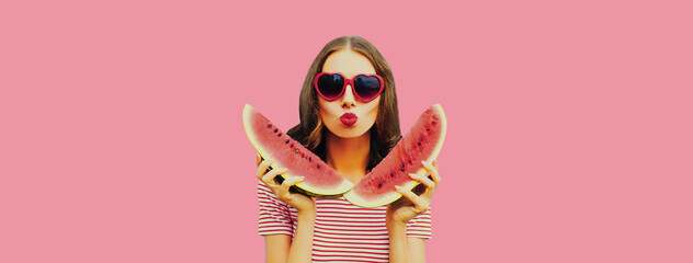 Summer portrait of beautiful young woman with slice of watermelon and blowing her lips with red...