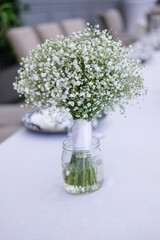 wedding table decor with a bouquet of white small delicate flowers