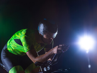 A triathlete rides his bike in the darkness of night, pushing himself to prepare for a marathon....
