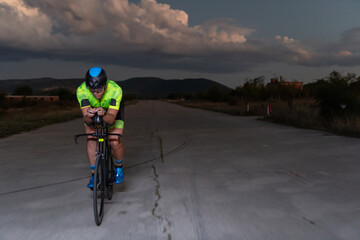A triathlete rides his bike in the darkness of night, pushing himself to prepare for a marathon....