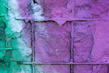 Old wall with rusty fittings painted in purple and green