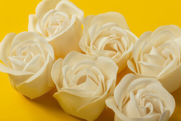 Six soap roses on bright yellow background, top angle view, close up. The concept of skin care, beauty, Valentine's Day.