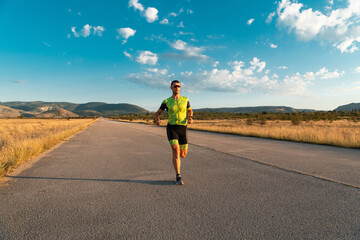 Obraz premium Triathlete in professional gear running early in the morning, preparing for a marathon, dedication to sport and readiness to take on the challenges of a marathon. 