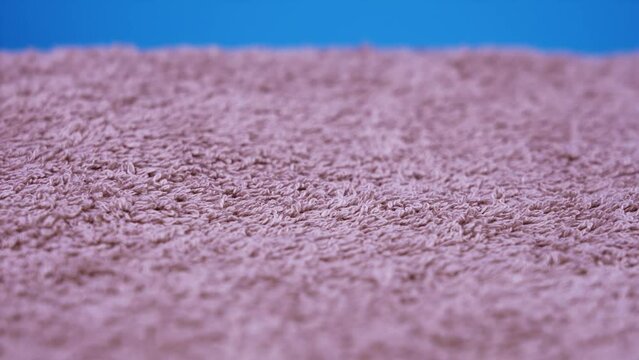 soft terry cloth of pink colour rotates under bright light
