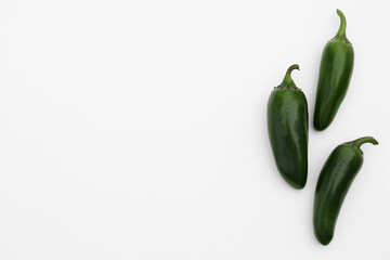 Green hot chili peppers on white background, flat lay. Space for text