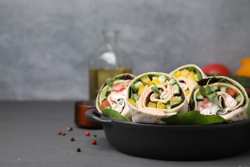 Fototapeta na wymiar Delicious sandwich wraps with fresh vegetables on grey table, closeup. Space for text
