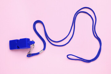 One blue whistle with cord on pink background, top view