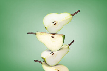 Cut fresh ripe pears on green gradient background