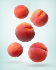 Fresh ripe peaches falling on light background