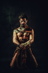 Fototapeta na wymiar Portrait of an ethnic warrior, kneeling, hands on his saber, gaze on the lens