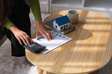 Cropped shot of female homeowner, using calculator planning banking loan debt payment .