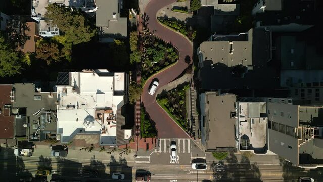 Drone flying above world famous curved Lombard street road and San Francisco city aerial view. Crossroad and streets aerial in historic town area. Landmark buildings on hills. 4K. 