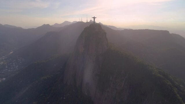 RIO DE JANEIRO, BRASIL - MAY, 2023: Drone aerial view of of a famous landmark Christ the Redeemer statue on Corcovado mauntain at sunrise. most visited tourist site in Rio at sunny day from above.