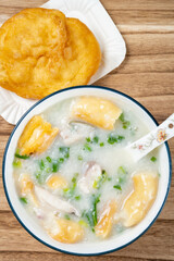 top view fish porridge with deep-fried Chinese donuts at vertical composition