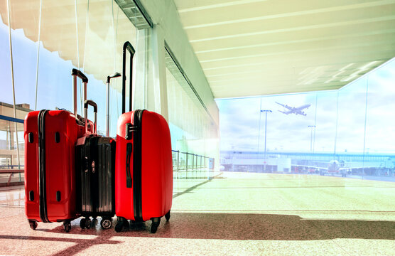 stack of traveling luggage in airport terminal building with passenger plane flying background