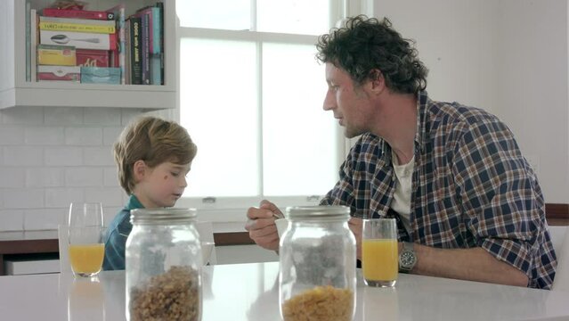 Food, breakfast and father with son at table for conversation, bonding and health in the morning. Affectionate, discussion and eating cereal with dad listening to child in family home together - Powered by Adobe