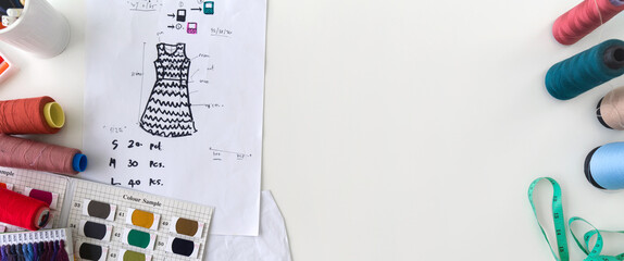 Fashion designer room. Pattern for cloth, silk thread color sample catalog, tape measure and sketching place on a large table. Top View