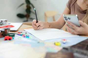 Women tourist planning vacation with the help of world map with other travel accessories around, travel concept.