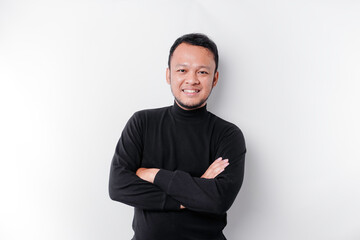 An Asian young confident man posing with crossed arm against a white background.