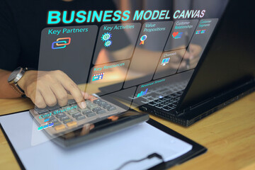 Business people using calculator to calculate the cost with the business model canvas or BMC tools...
