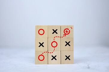 Strategy concept to do business through xo game and reach success goal in wooden block style.