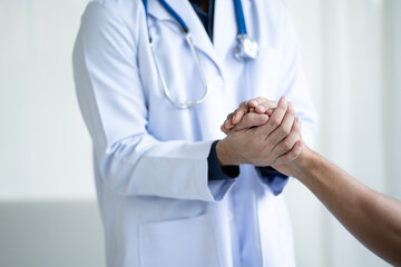 Close up view of friendly doctor hold patient hand in office during the visiting. giving hope and empathy.