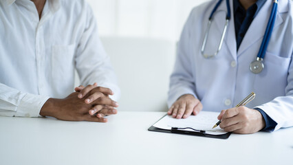Close up view of professional physician consulting with male patient, talking to male client at medical checkup visit