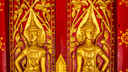 Fototapeta na wymiar Golden fresco at Wat Hosian Voravihane Buddhist Temple in Luang Prabang Laos