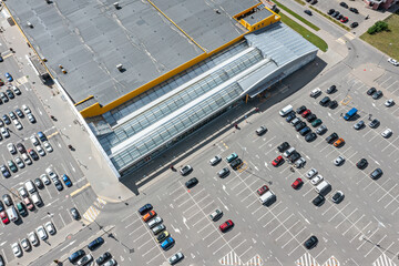 aerial view of shopping mall parking lot with cars standing on parking lot place.