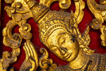 Fototapeta premium Golden fresco at Wat Hosian Voravihane Buddhist Temple in Luang Prabang Laos