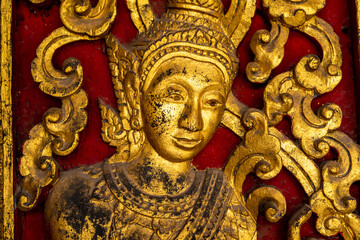 Fototapeta premium Golden fresco at Wat Hosian Voravihane Buddhist Temple in Luang Prabang Laos