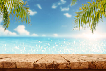 Empty wooden table are placed outdoors on spring sunny sky background with blue sparkling sea water and bokeh blurry. Counter display concept