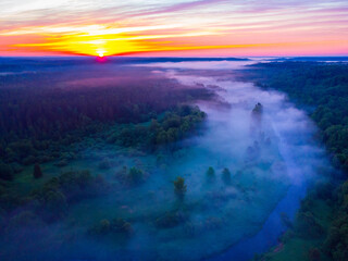 Fototapeta na wymiar Drone's Eye View: Serene Sunrise Over Misty River and Woodland Landscape in Northern Europe
