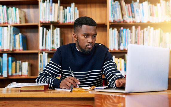 Laptop, library and university student with research, learning and planning for exam, report or focus on studying, goals and education. Black man, college and working on task, essay or scholarship