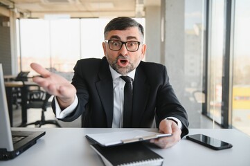 Fototapeta premium Angry businessman with document shouting at somebody