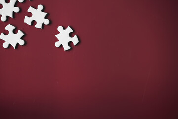 Clean puzzle elements on the red background. Empty puzzle piece on the table. Teamwork concept.