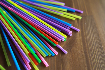Obraz premium Colorful plastic drinking straws, close up as background. colored tubules for juice and cocktails on black wooden table