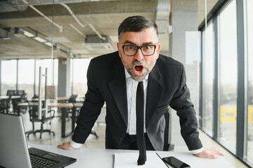 Angry businessman with document shouting at somebody