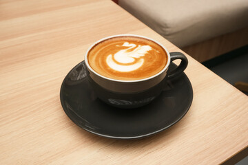 A cup of hot latte coffee on the table for breakfast

